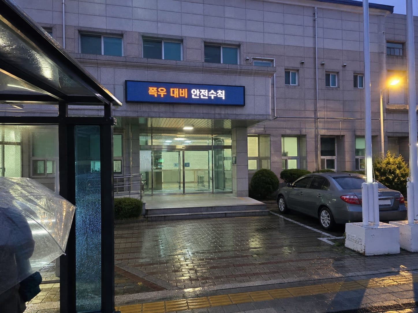 비 오는 저녁 한국 공공청사 현관 상단 전자현수막에 표시된 폭우 대비 안전수칙